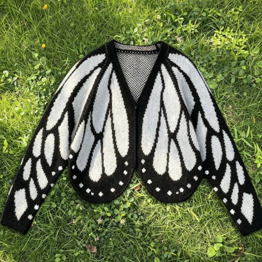 Close view of the white butterfly wing cardigan showing the scalloped hem