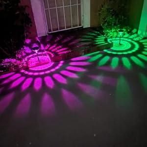 Magenta and green sunburst light patterns on a patio at night