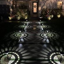 Warm white sunburst lights lining a walkway to a front door