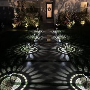 Warm white sunburst lights lining a walkway up to a front door