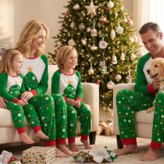 Family and puppy on the sofa in matching tree pajamas