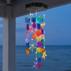 The chime lit at dusk by the sea