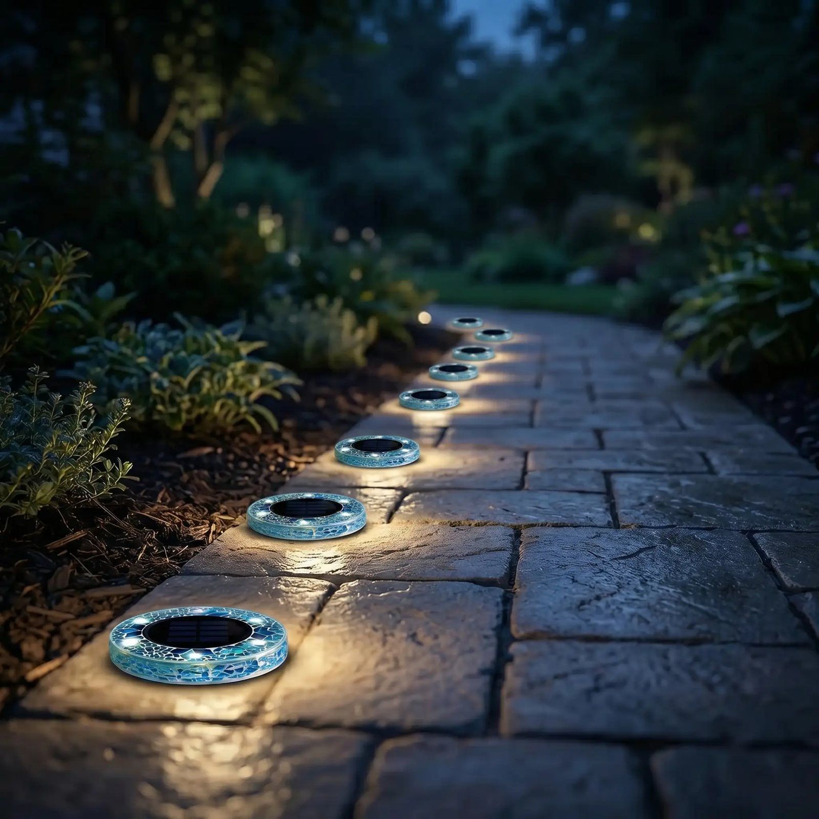 Driveway and pathway lined with glowing blue mosaic solar disk lights at night