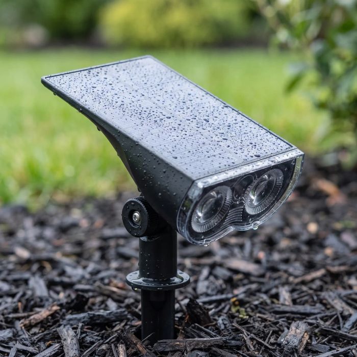 Solar-powered dual-lens spotlight on a ground stake, weatherproof for outdoor use