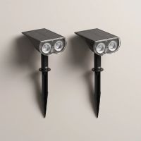 Two smart solar spotlights with ground stakes laid out, the two-pack contents