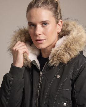 Close shot of the black bomber jacket with the faux fur hood trim framing the face