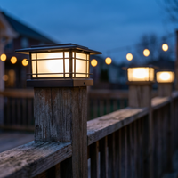 Black post cap light glowing at dusk