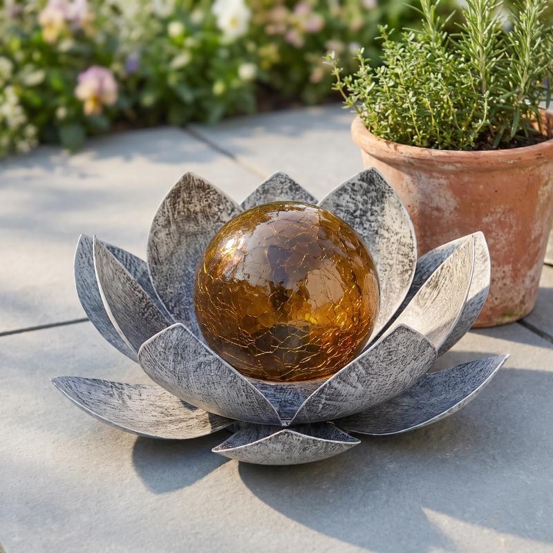 Pewter lotus resting on a patio in daylight