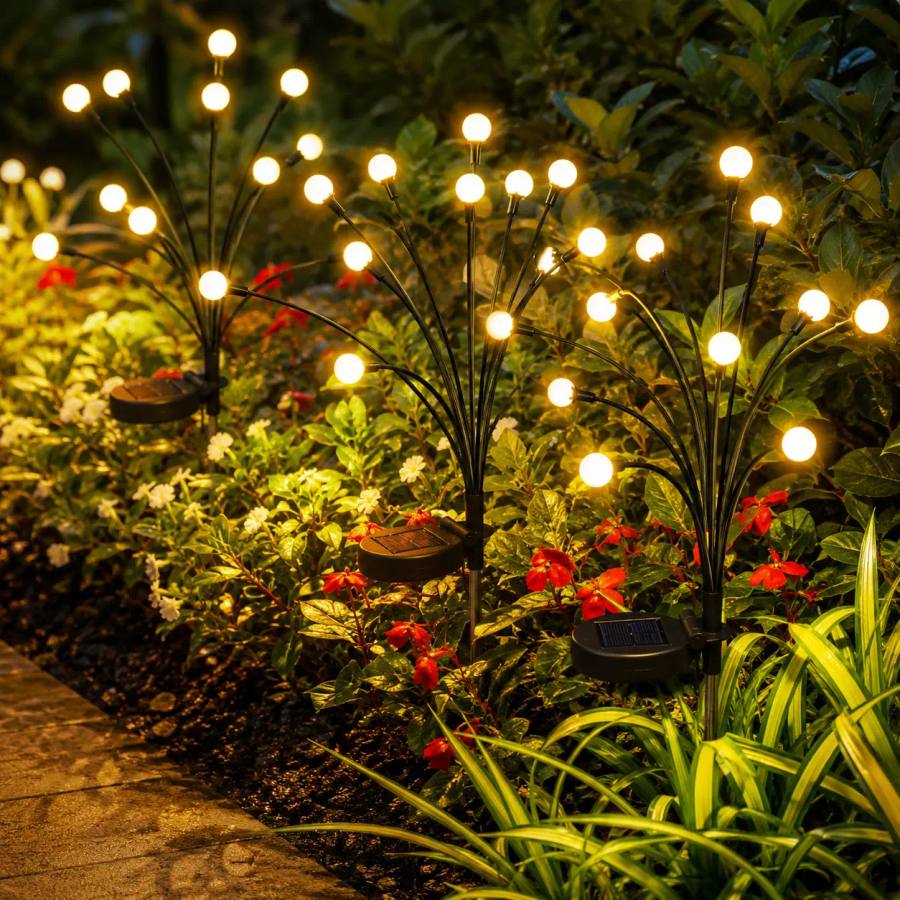 Close-up of warm glowing firefly orbs on flexible stems