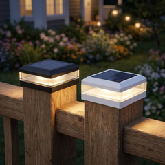 Black and white solar fence post cap lights glowing on a timber fence at dusk