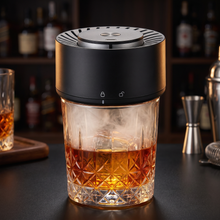 Electric whiskey smoker infusing a glass of whiskey with cool wood smoke