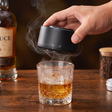 The smoker lifted off the glass by hand, showing its size