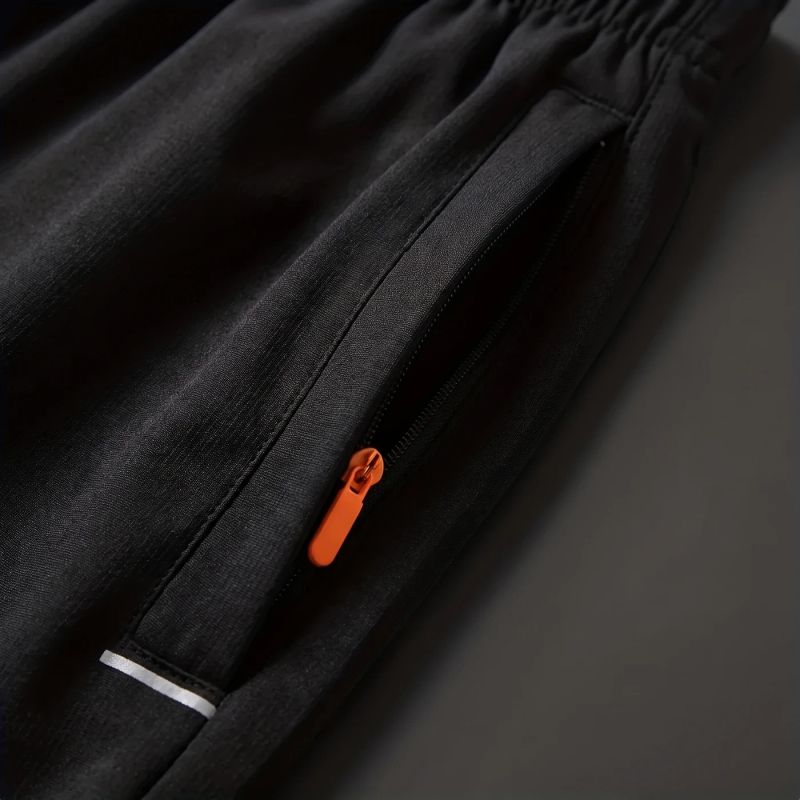 Close-up of the zippered side pocket with an orange pull and reflective stripe