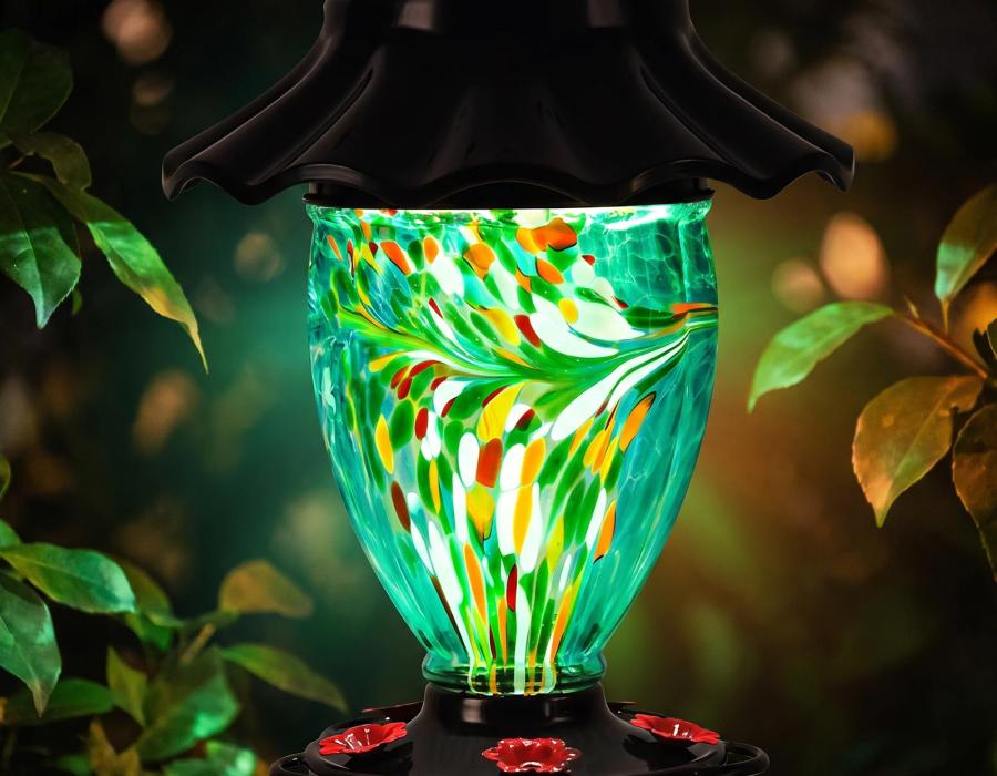 Solar hummingbird feeder glowing in rainbow RGB colors at night
