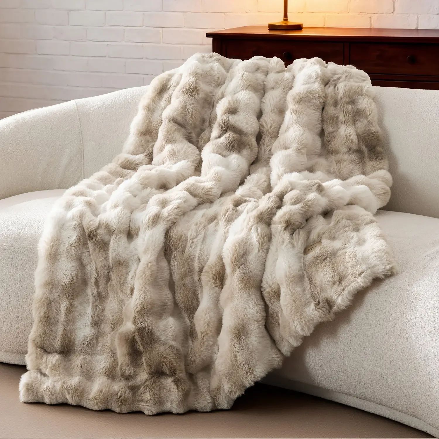 The blanket draped over the arm and seat of a sofa