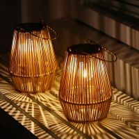 Two rattan solar lanterns glowing on a windowsill