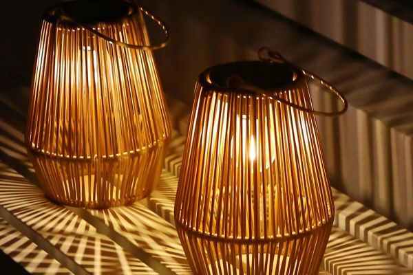 Two rattan lanterns glowing warmly at home