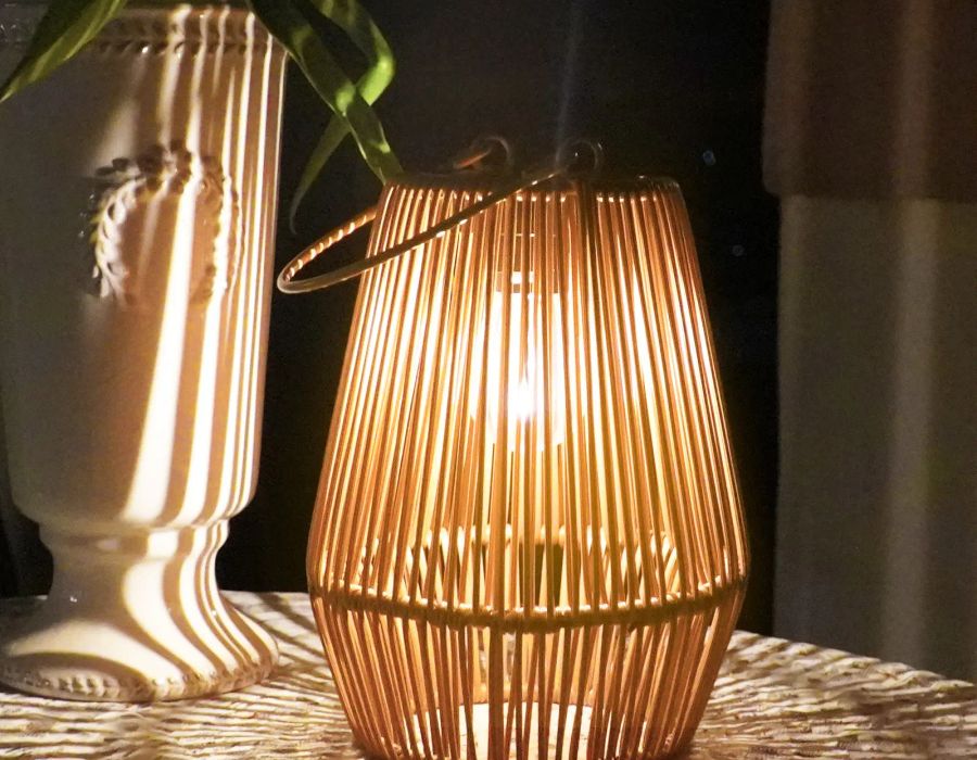 Rattan lantern standing on a table indoors with a warm glow