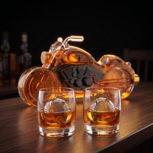 Two whiskey glasses over clear ice with the decanter behind